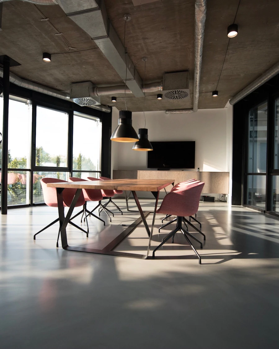 Espacio de trabajo corporativo con zona de reuniones y grandes ventanales